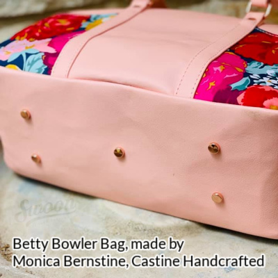 Base of the Betty Bowler Bag made by Monica Ann Bernstine from Castine Handcrafted in pink faux leather, showing the bag's purse feet