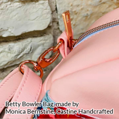 Close-up of the Betty Bowler Bag made by Monica Ann Bernstine from Castine Handcrafted in pink faux leather, showing a rose gold swivel clip
