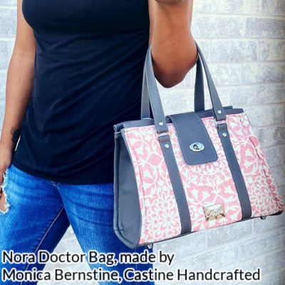 Nora Doctor Bag, made in pink and grey by Monica Ann Bernstine of Castine Handcrafted. The bag is carried on the arm of a brown-skinned woman wearing a black top and torn blue jeans.