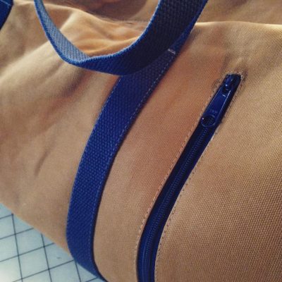 Close-up of the Vintage Dallas Duffel Bag from Swoon Patterns, showing the vertical zippered pocket
